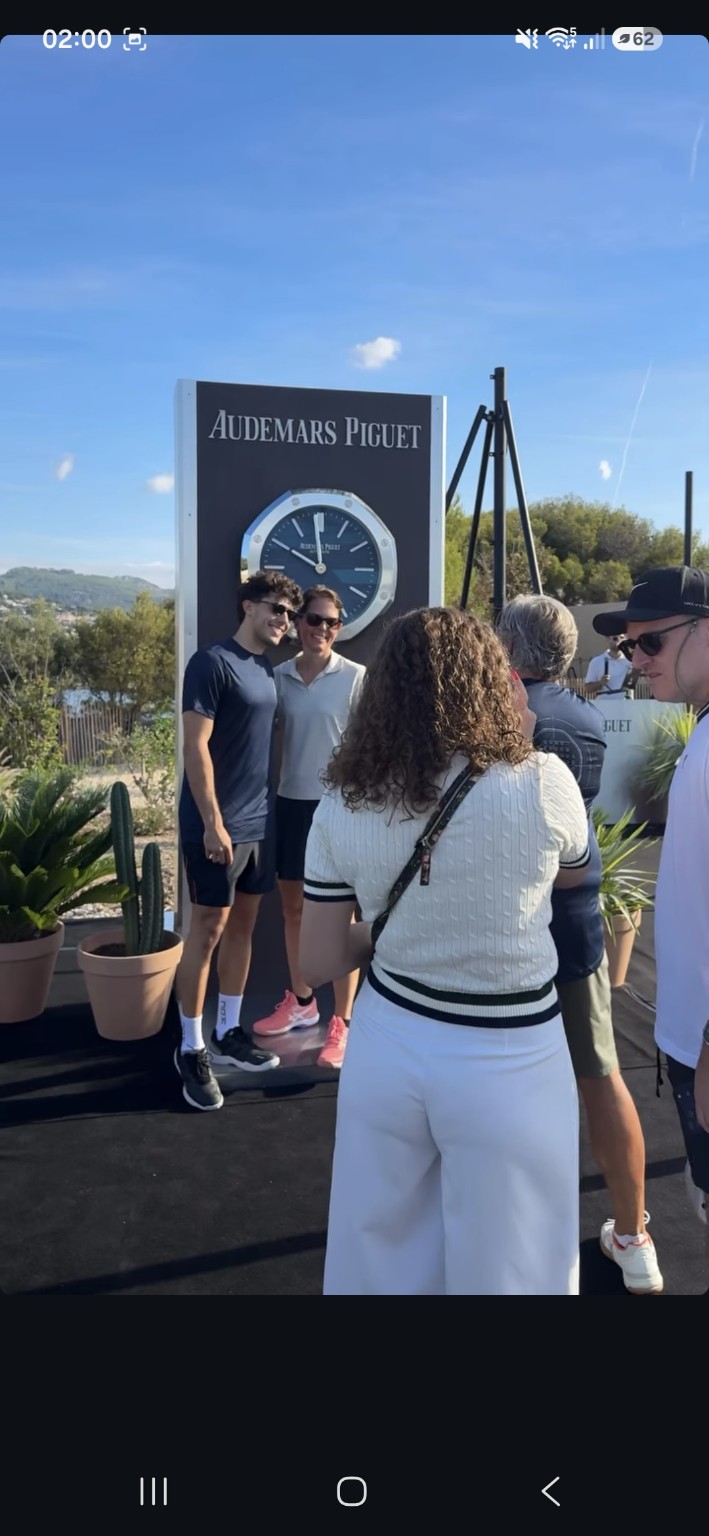 Invités photographiés devant une grande horloge Audemars Piguet pendant le Pro-Am