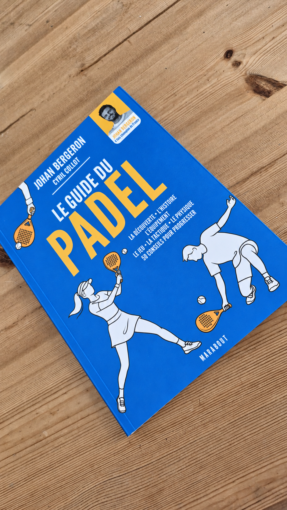Le Guide du Padel de Johan Bergeron et Cyril Collot posé sur une table en bois