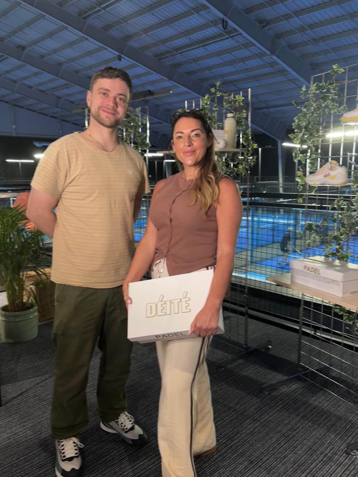 Aimée Lawson et un invité dans un club de padel, avec une boîte et des chaussures de la marque DÉITÉ