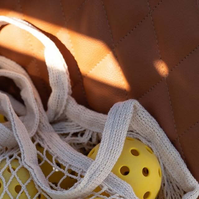 Sac en maille et balles jaunes photographiés pour l’ouverture de Racquet Club Gold Coast
